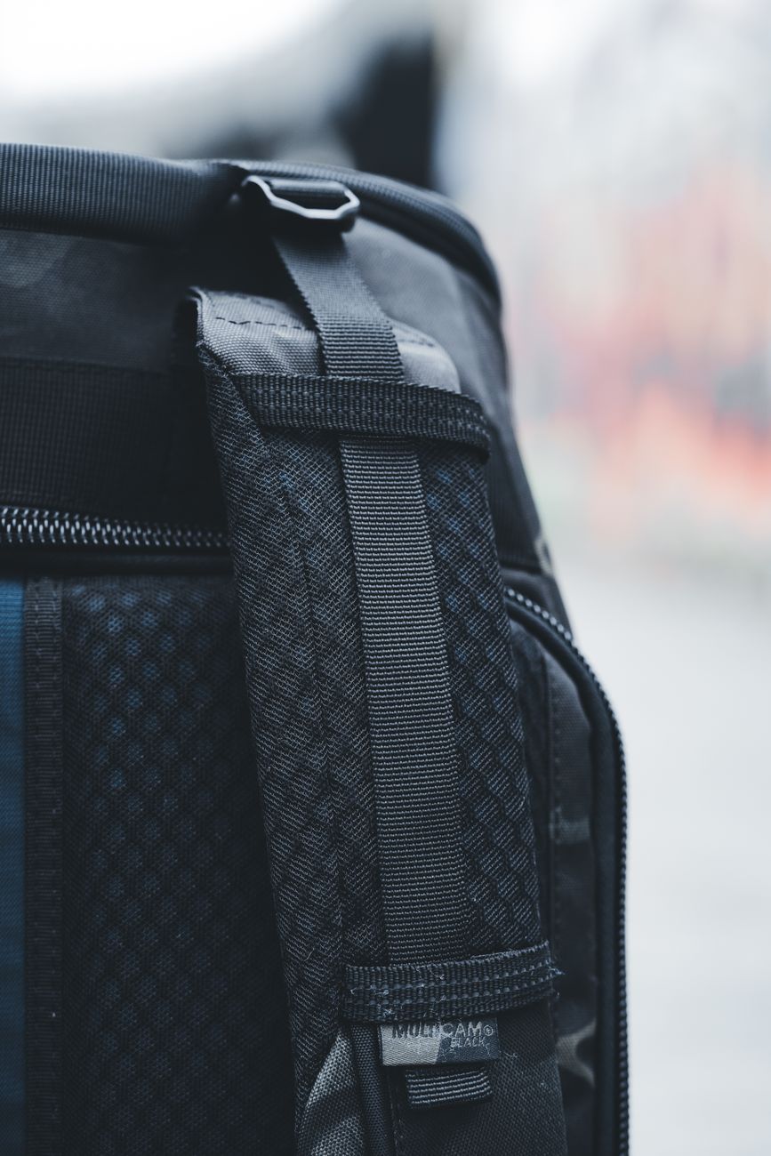 Detailed close-up of a black backpack showing the intricate strap design.