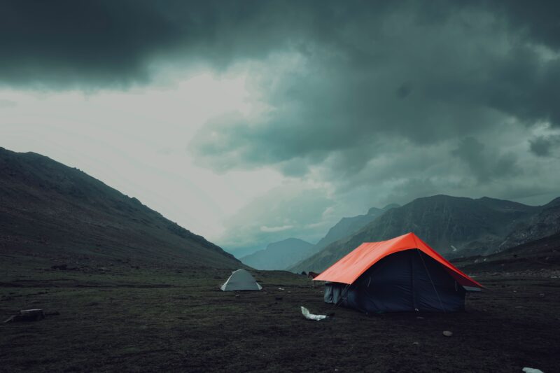Ultralight backpacking tents pitched in a mountain valley, illustrating Dyneema vs Kevlar fabric choices