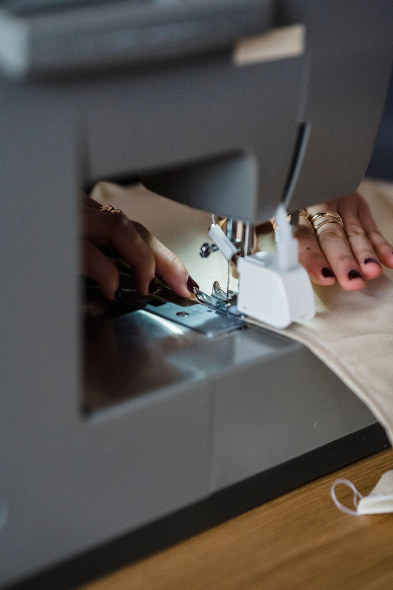 Close-up of someone sewing white fabric on a machine, illustrating a DIY Tyvek or Dyneema backpacking gear project