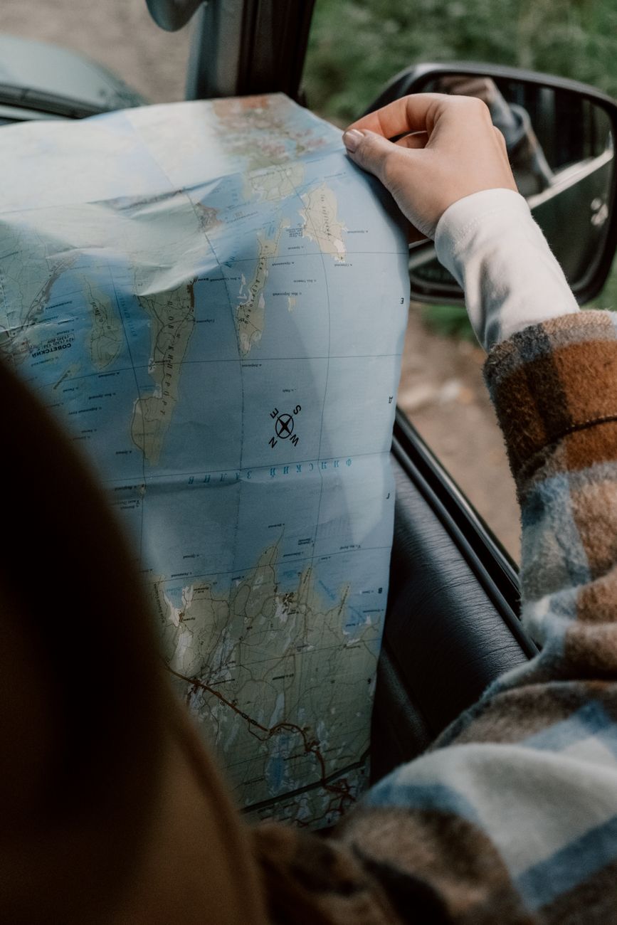 person in plaid long sleeve shirt holding a map