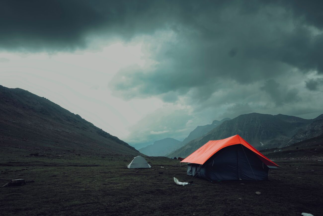 Silpoly and Dyneema tents pitched in a mountain valley under storm clouds