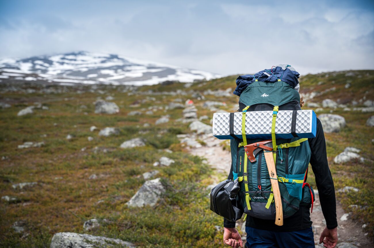 Hiker wearing an ultralight backpacking pack on a rocky mountain trail