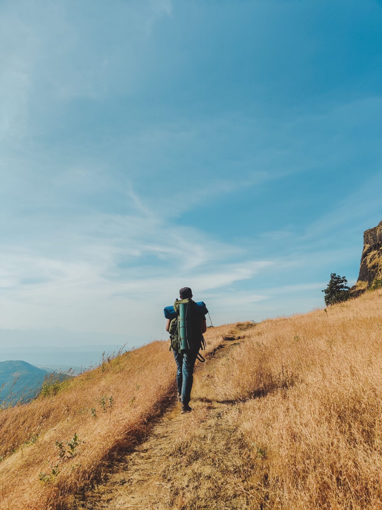 Hiker wearing an ultralight backpack similar to Hyperlite Unbound or Zpacks Arc Haul Ultra on a mountain trail
