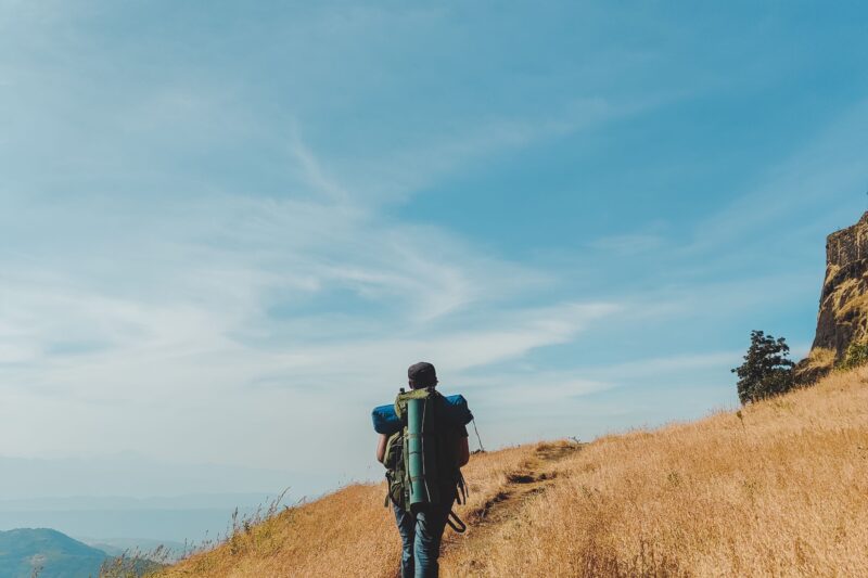 Hiker wearing an ultralight backpack similar to Hyperlite Unbound or Zpacks Arc Haul Ultra on a mountain trail